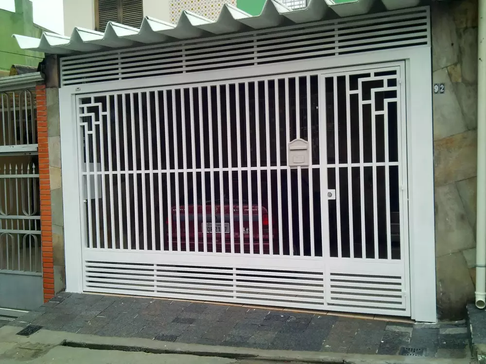 Portão pivotante branco com grade geométrica